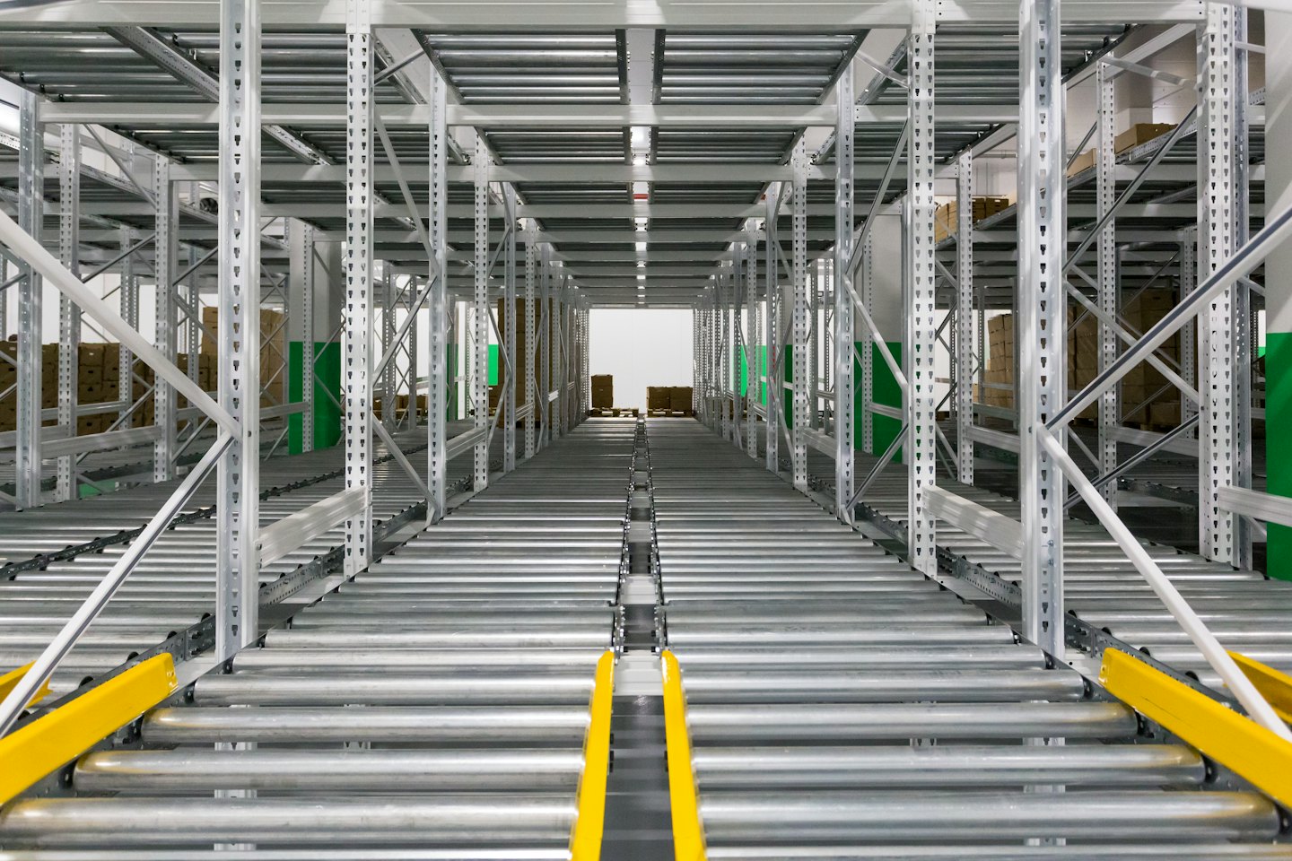 Warehouse aisle with gravity flow racking and boxes.